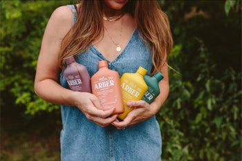 Woman harvesting vegetables, fruits, and flowers from raised garden bed